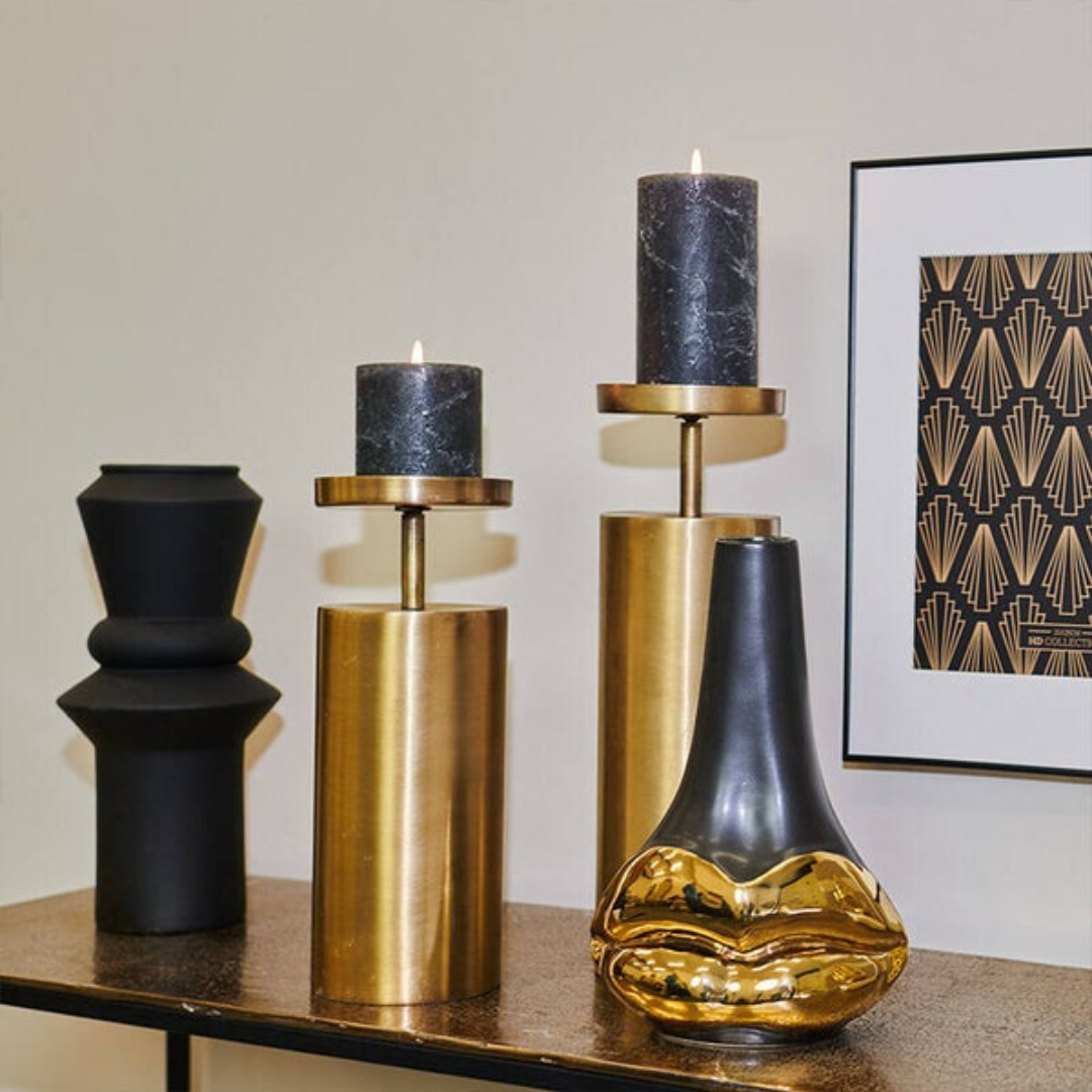 Close-up of solid brass candlestick set showing brushed metallic finish and modern silhouette