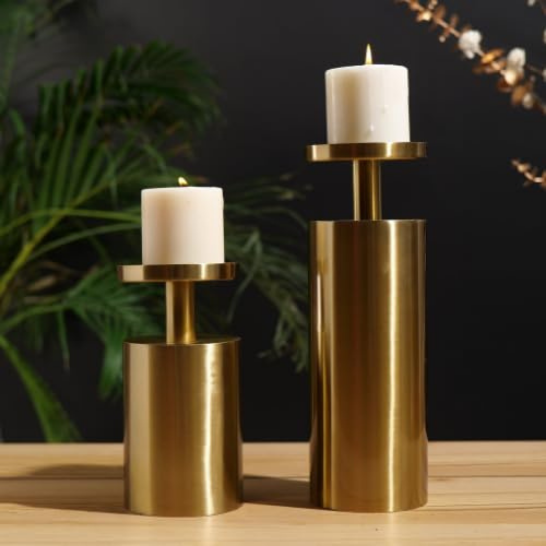 Three-piece solid brass pillar candlestick set displayed together on a flat surface