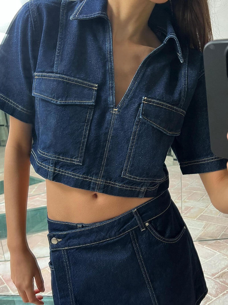 Denim cropped top with front zipper and contrast stitching, paired with a figure-hugging mini skirt