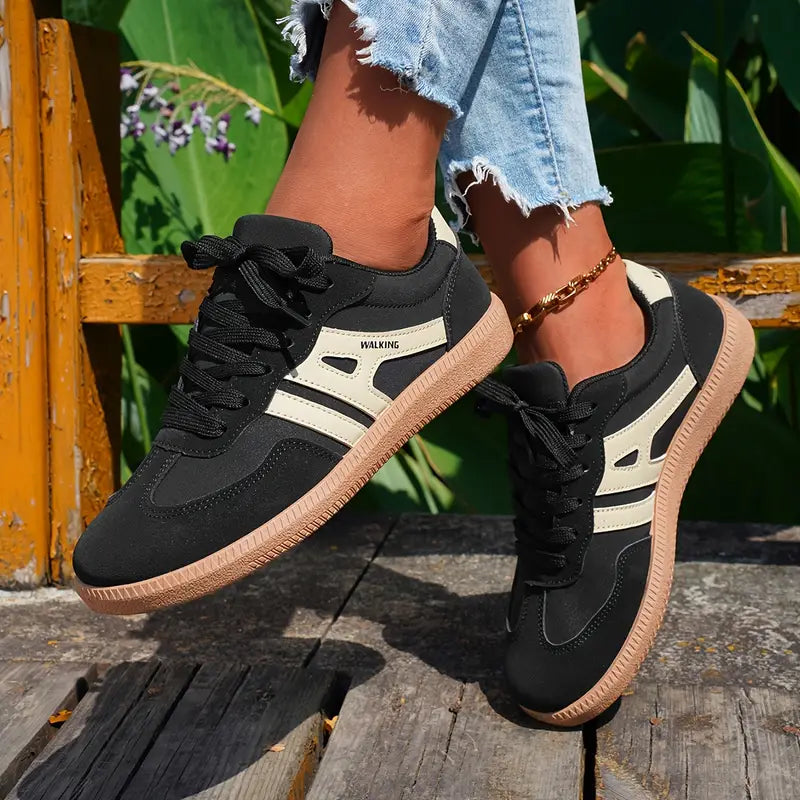 Low-silhouette women's sneakers featuring multi-panel construction and stitched reinforcement details