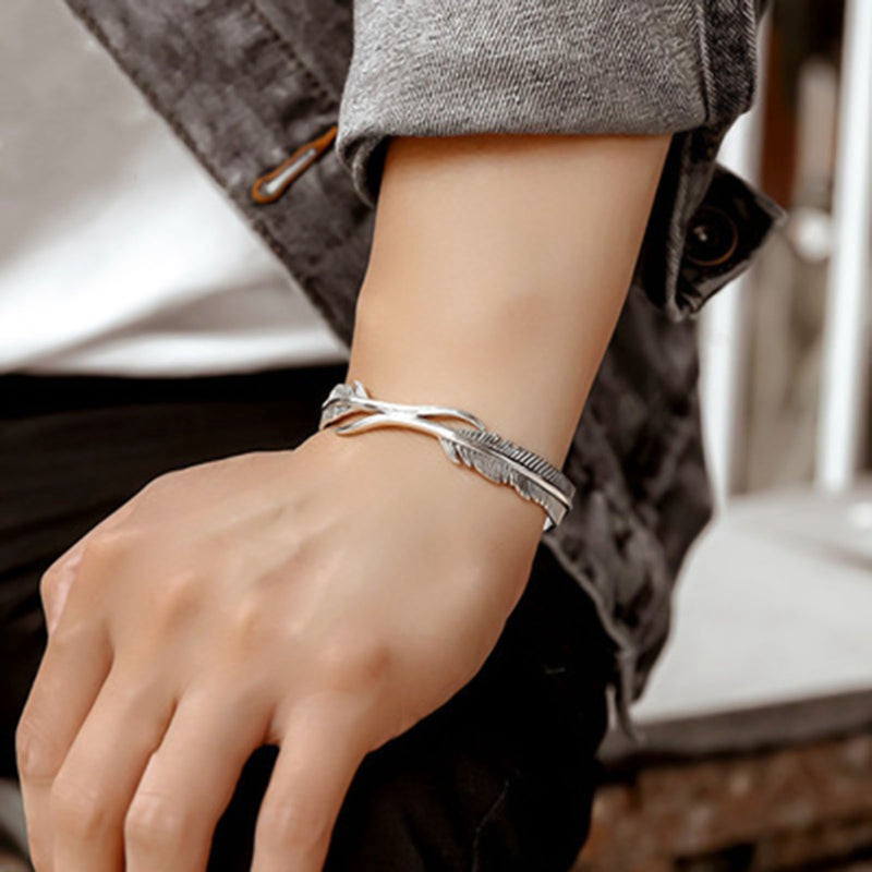 Close-up of feather bracelet showing detailed feather engraving and polished surface