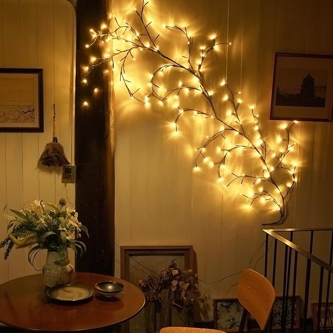LED tree branch string lights illuminated in a bedroom creating a cozy atmospheric glow