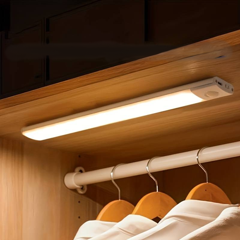 Rechargeable LED lamp with motion sensor mounted under a shelf in a wardrobe