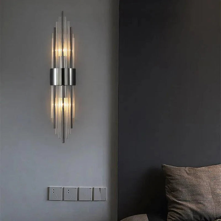 Vertically oriented metal wall lamp with glass elements for bedroom or hallway lighting