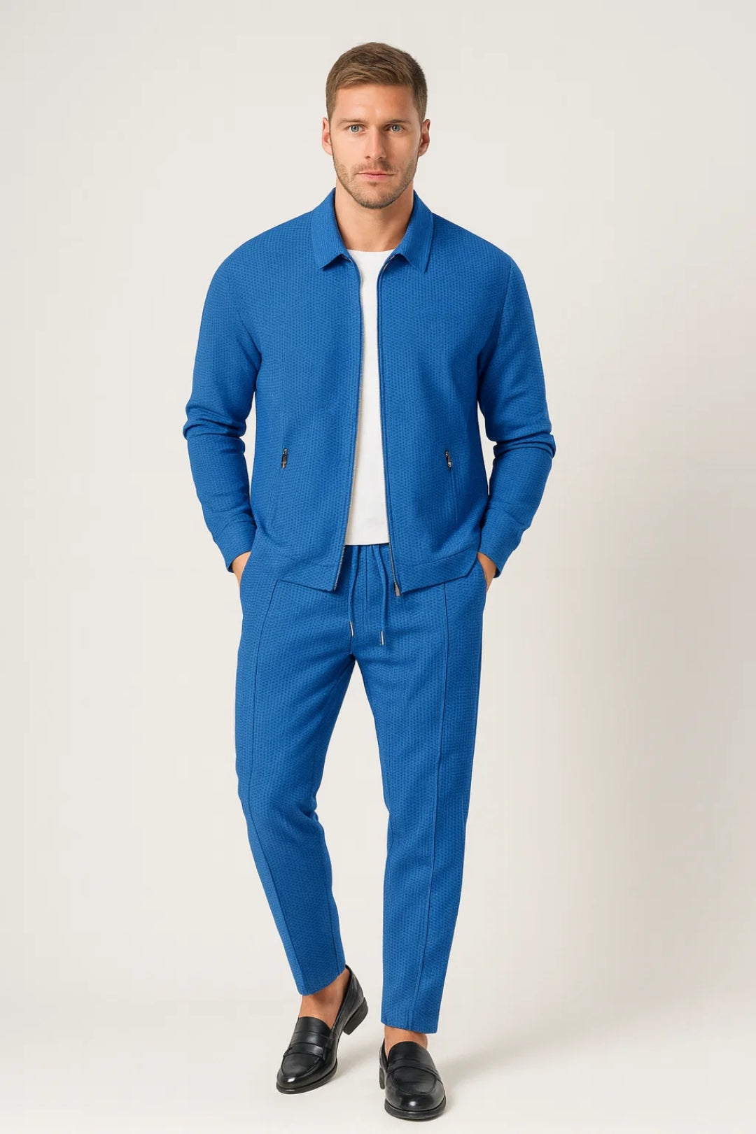 Men's textured tracksuit set with zip-up jacket and tapered drawstring pants in a relaxed casual style