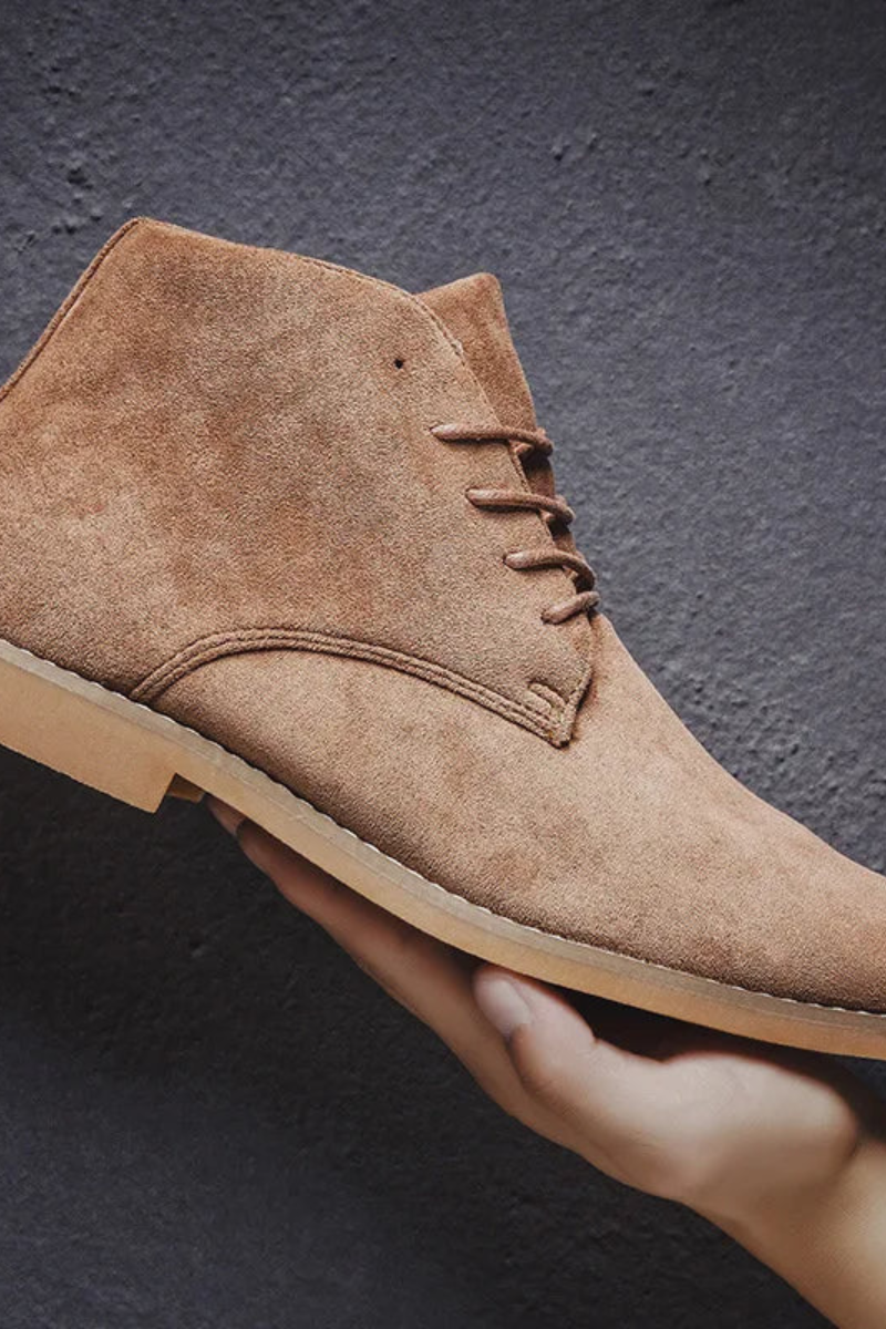 Men's suede desert boots — front three-quarter view showing minimalist lace-up silhouette