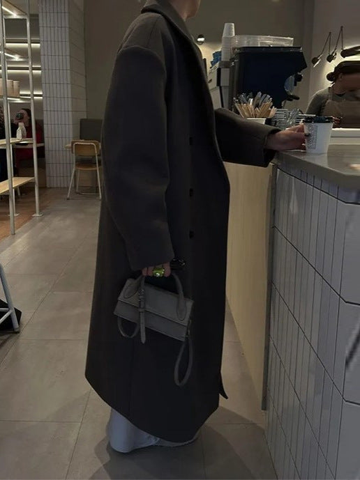 Full-length women's wool blend coat with long hem and regular fit, styled for autumn/winter