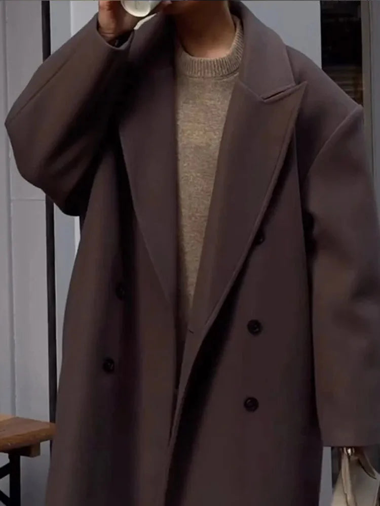 Side view of women's long wool blend coat with side pockets and structured woven fabric