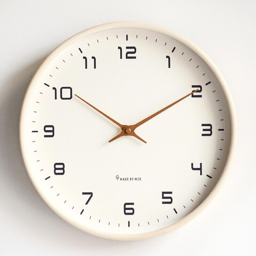 Round wooden frame wall clock displayed in a modern living room setting