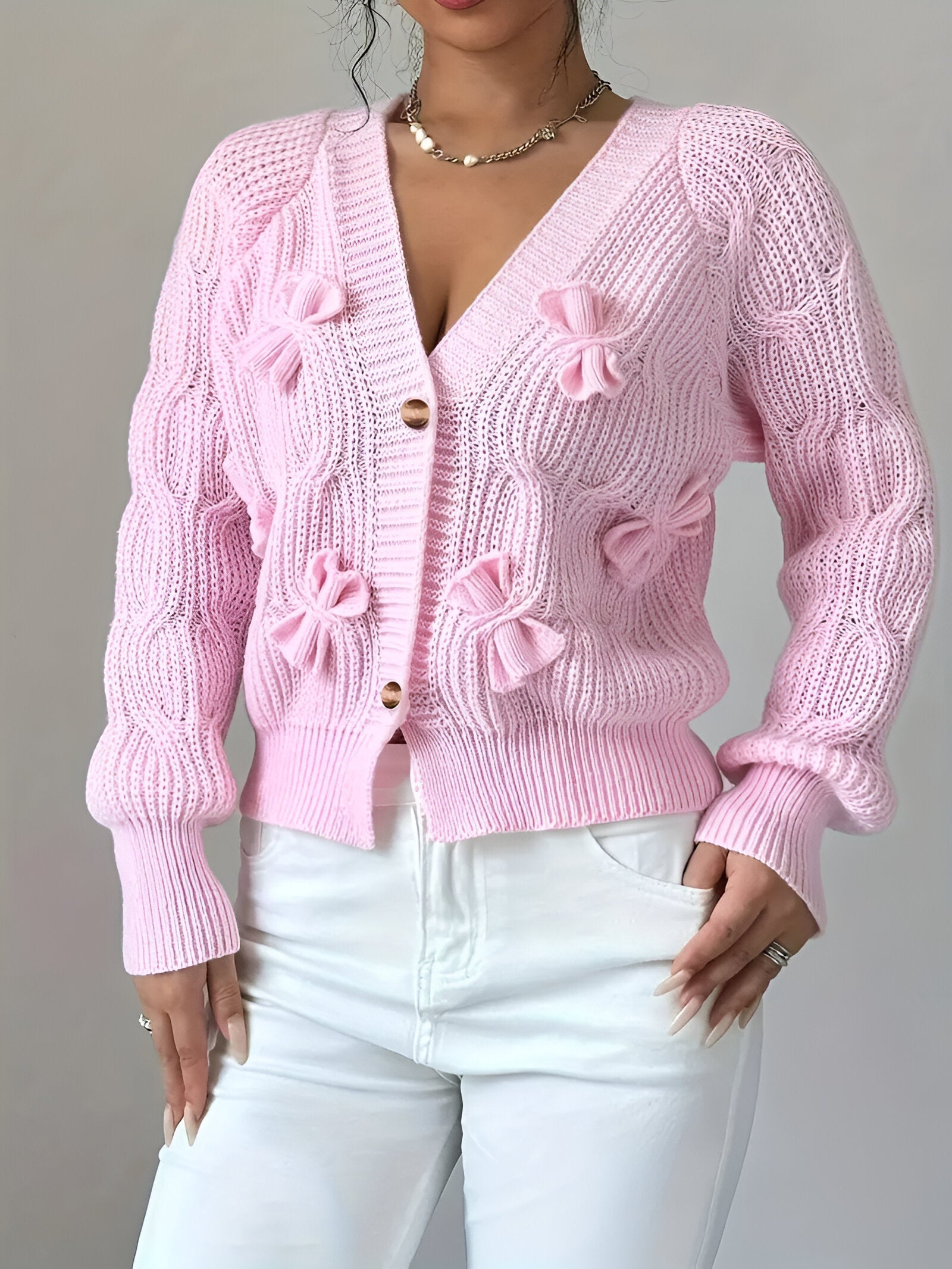 Women's knitted cardigan with bow details and button closure, front view