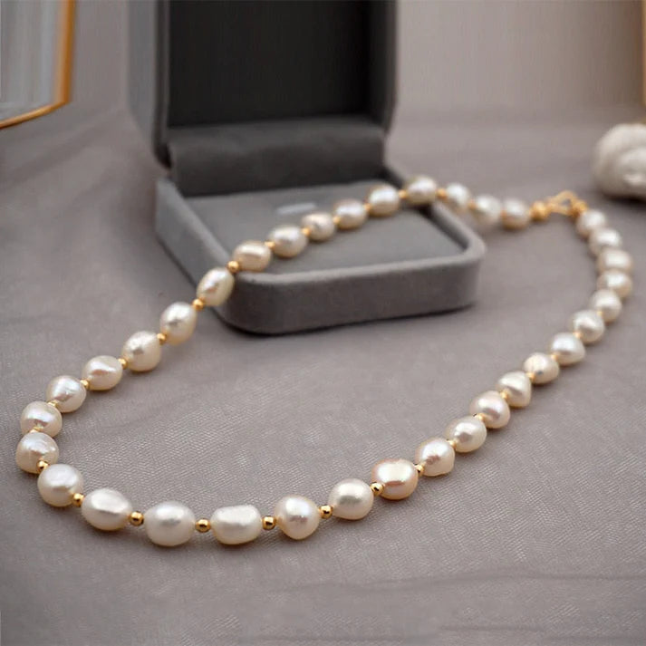 Women's pearl necklace with evenly spaced round pearls and a polished metallic finish