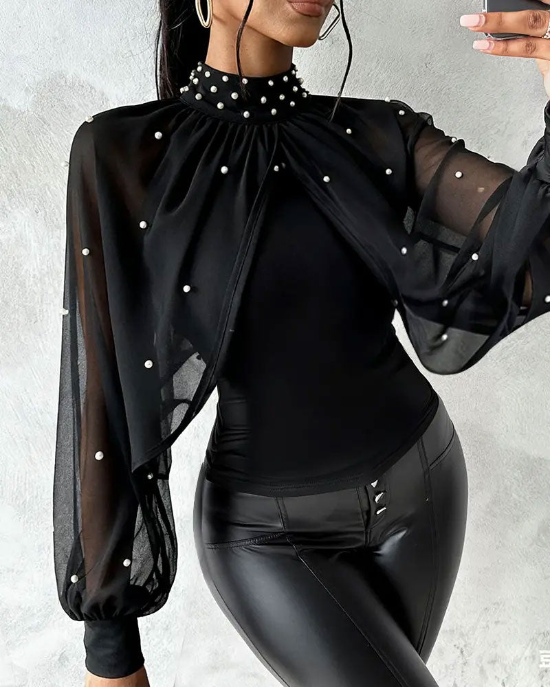 Close-up of women's sheer blouse showing high neckline and decorative sleeve detail
