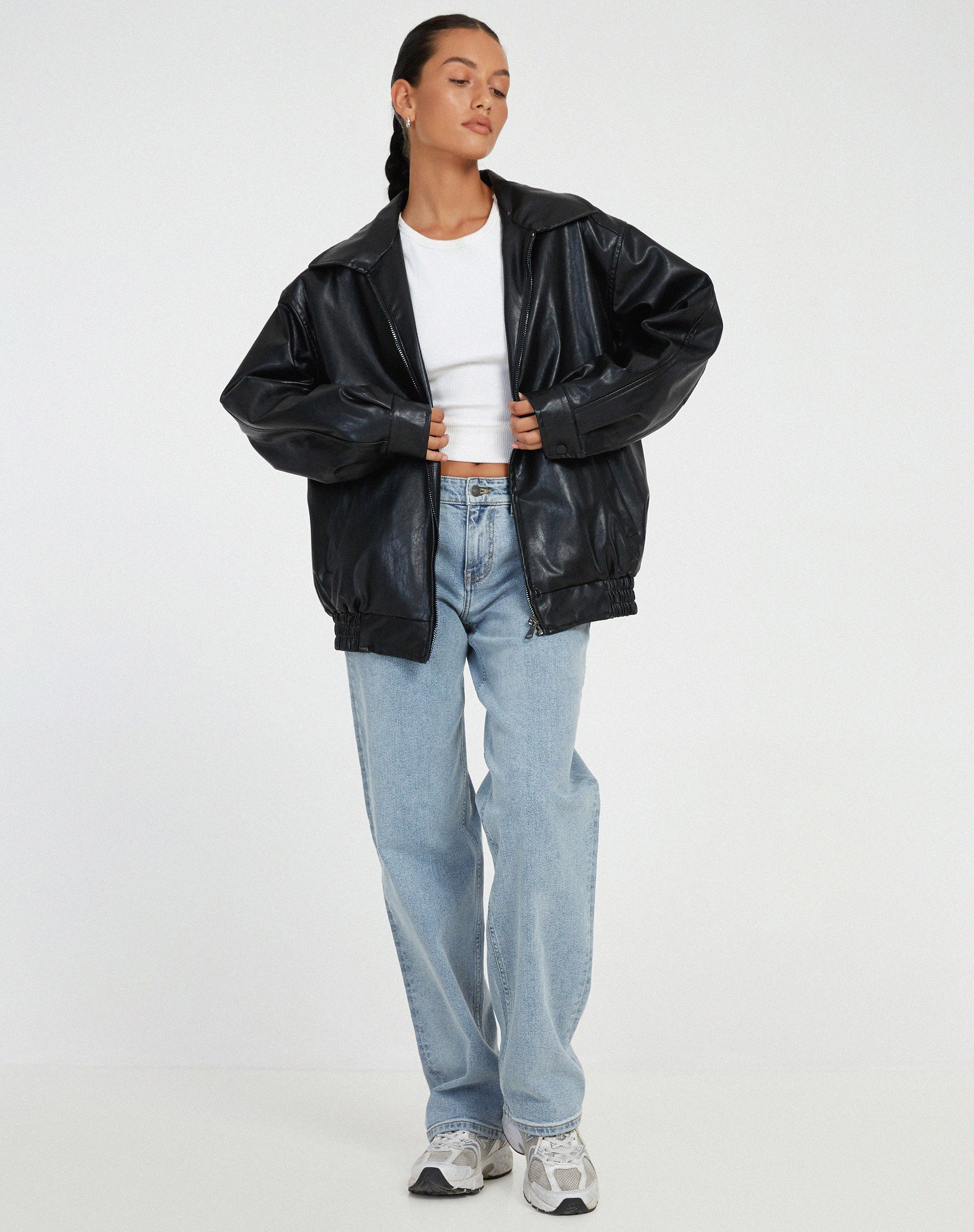 Women's oversized vegan leather jacket side profile showing generous fit and hip-length silhouette