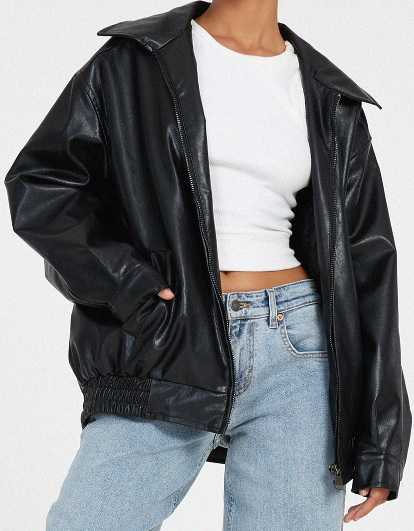 Women's oversized vegan leather jacket worn open, showing polyester lining and relaxed drape