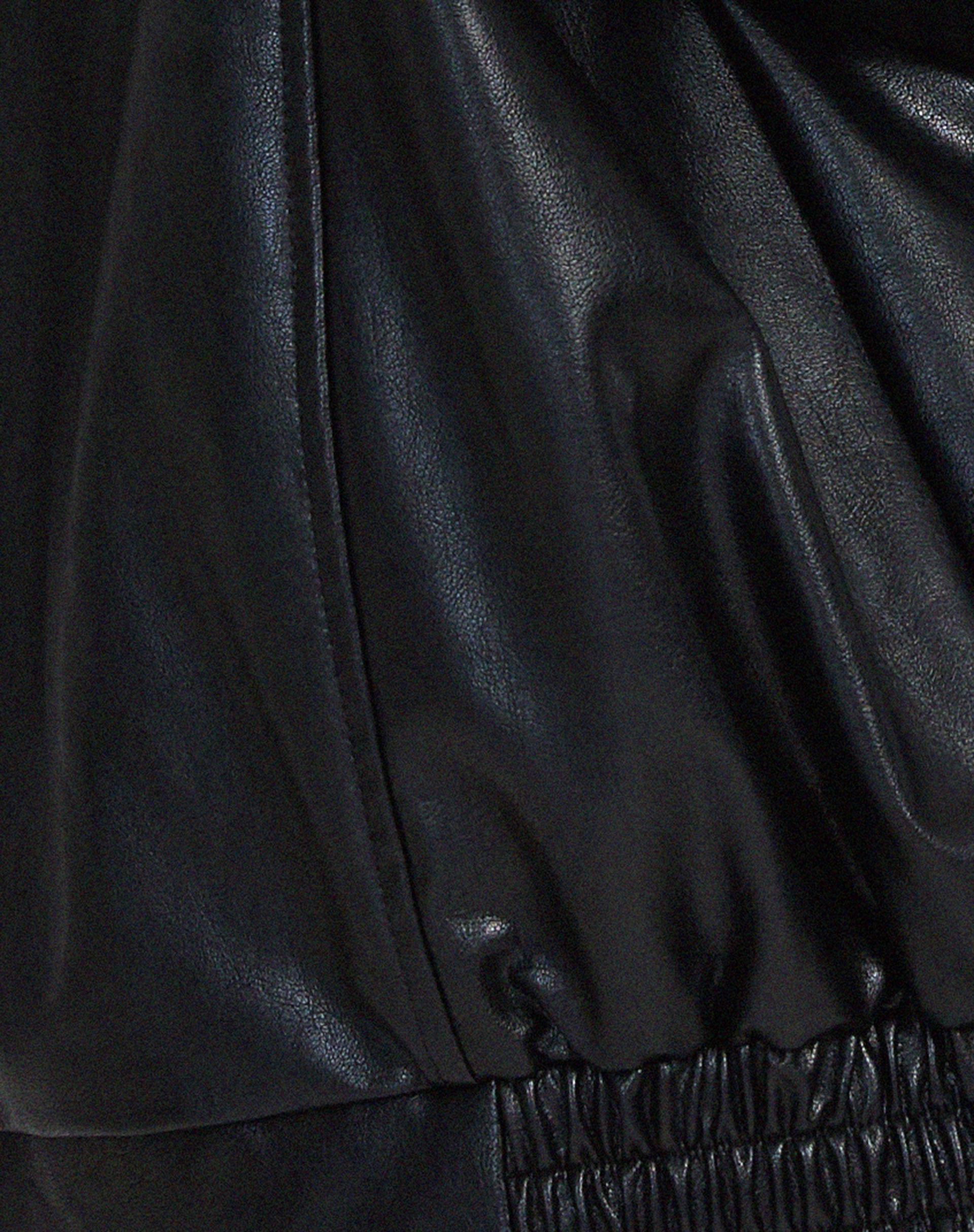 Women's oversized vegan leather jacket styled as outerwear, showing hip-length cut and wide collar detail