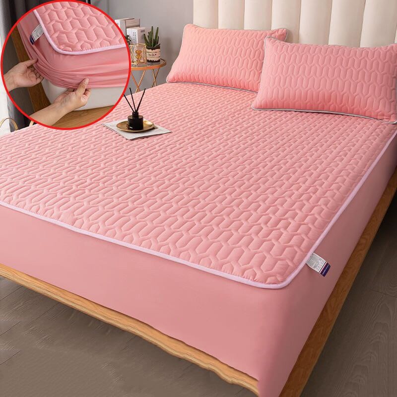Quilted mattress protector on a neatly made bed in a bedroom setting