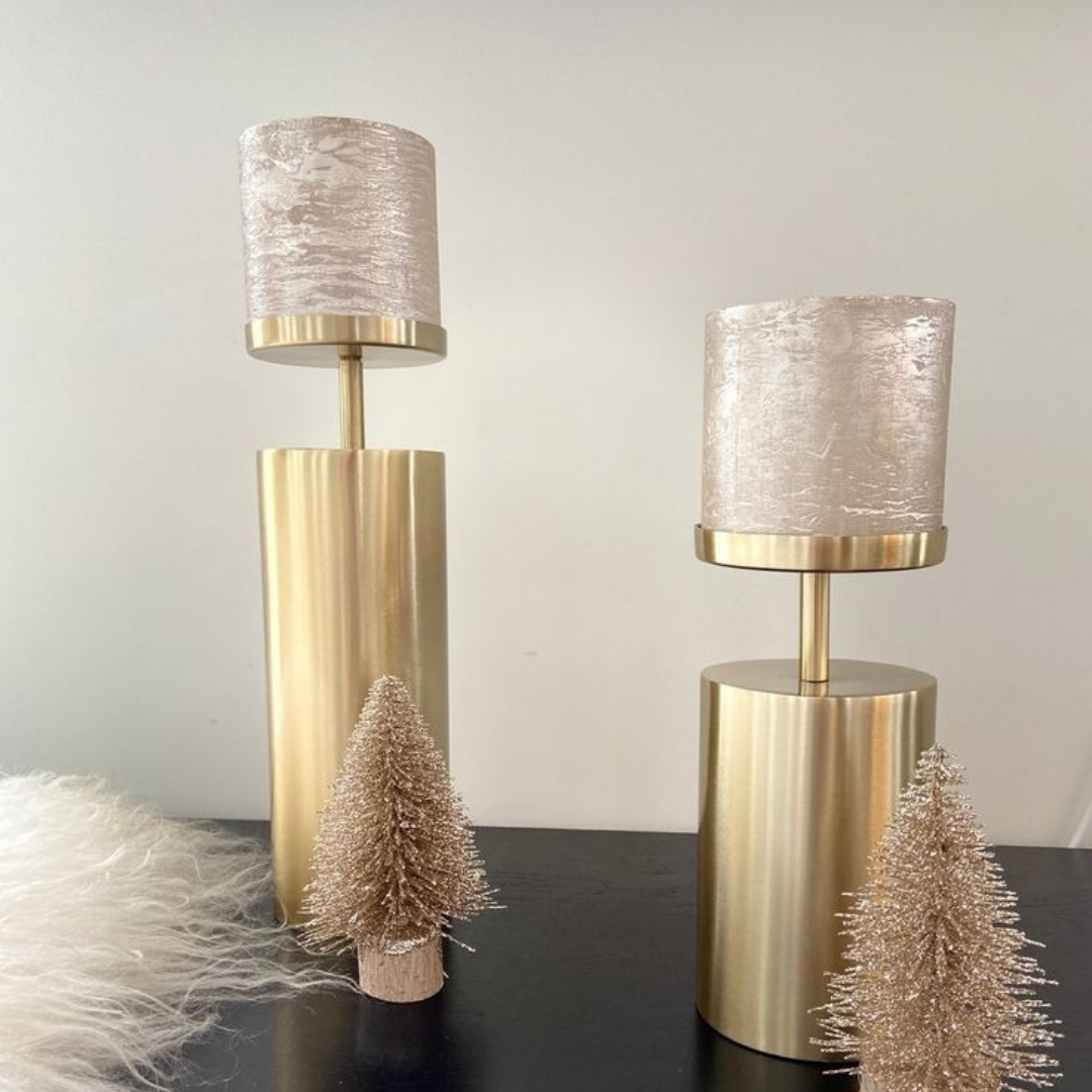 Brass pillar candlestick set styled in a home décor setting as a tabletop centerpiece