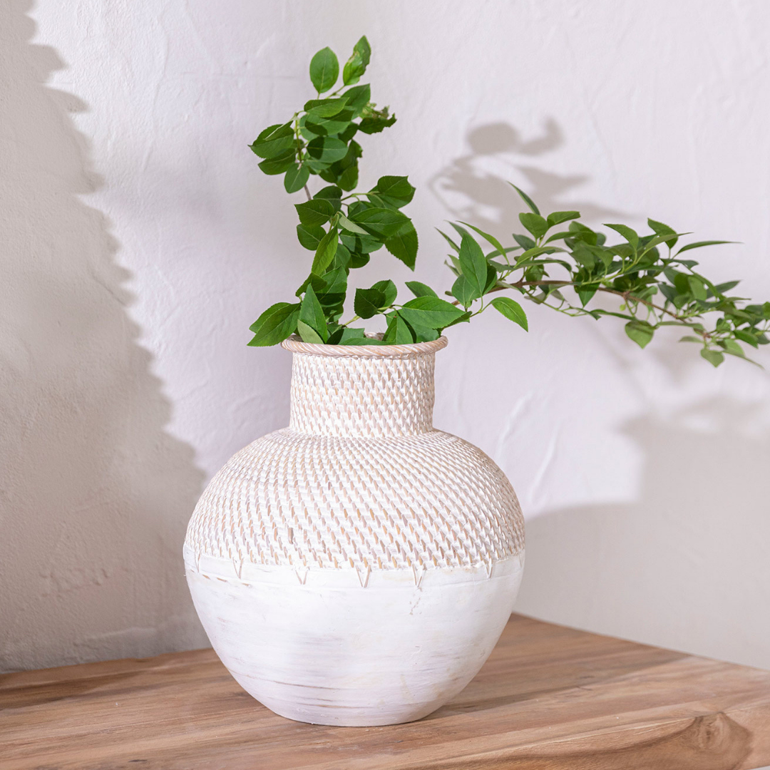 Handmade woven ceramic vase with textured upper structure on a clean surface
