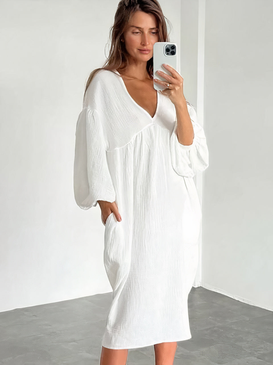 Women's loose midi dress with V-neckline, straight hem, and elastic cuffs in a spring-ready silhouette