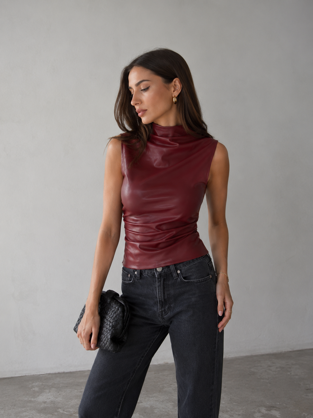Women's sleeveless faux leather top with high neckline and figure-hugging silhouette