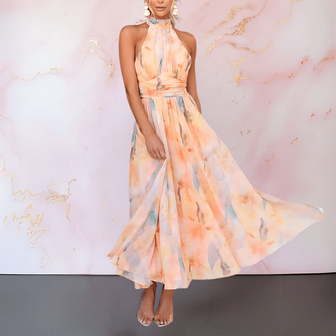 Halterneck midi dress with abstract pattern showing defined waist and flowing pleated skirt