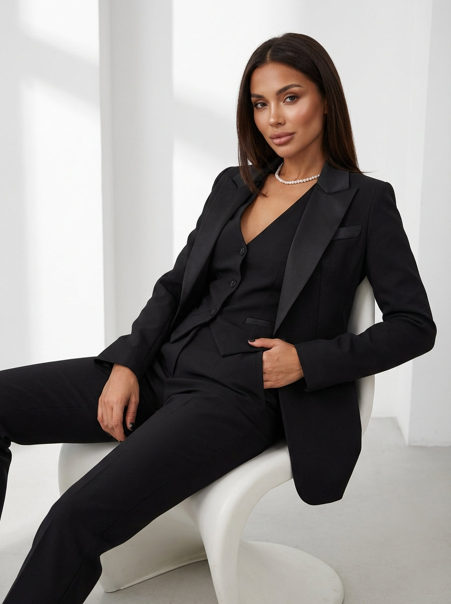 Close-up of women's suit blazer lapel and single-breasted button closure from a three-piece tailored set