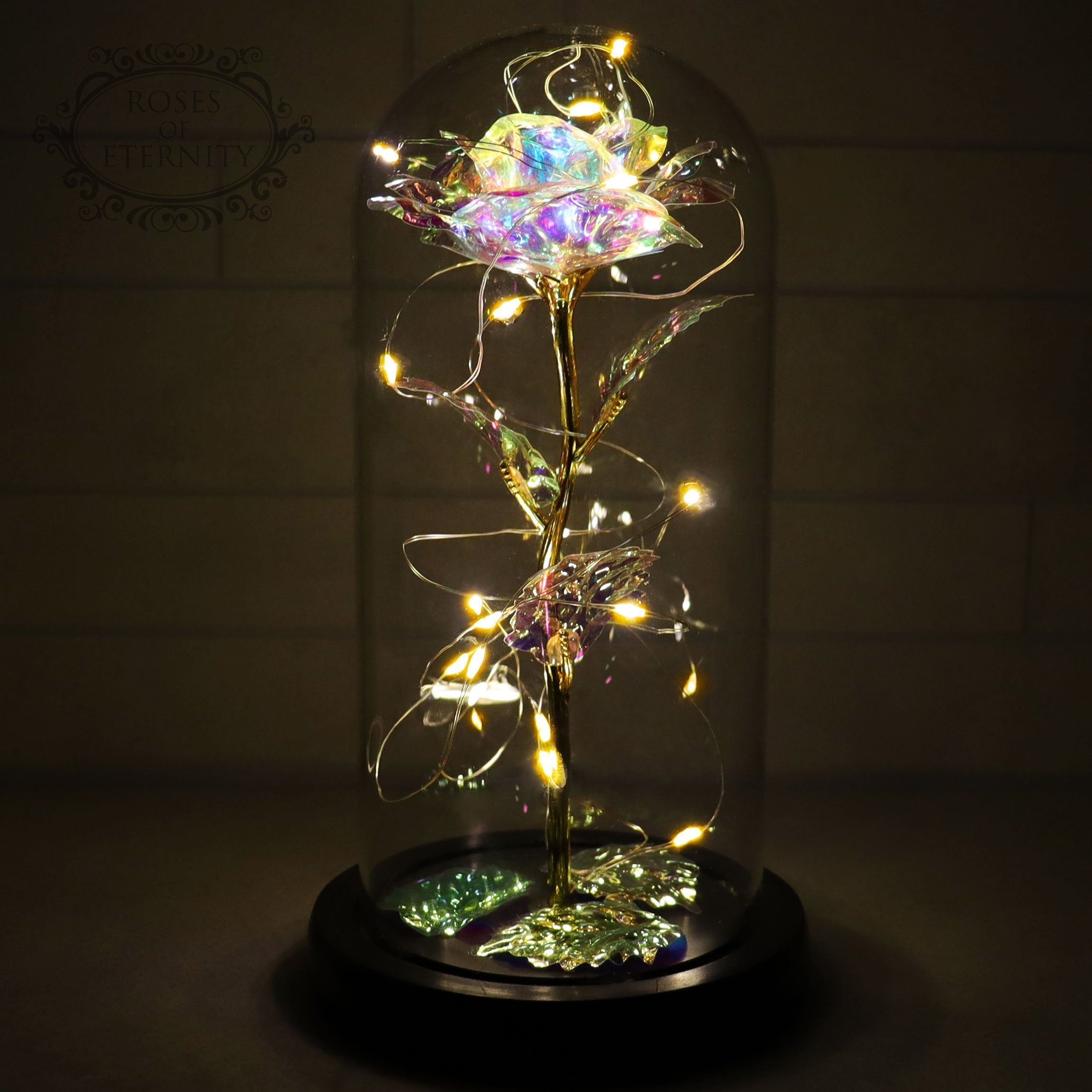 Decorative glass dome with glowing LED flower casting warm ambient light on wooden base