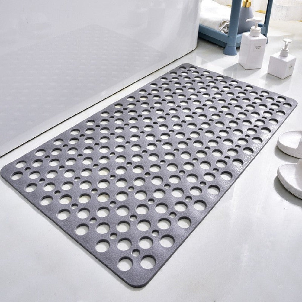 Rubber bathroom mat with evenly spaced perforations for water drainage on bathroom floor
