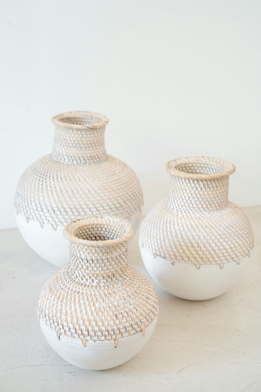 Handmade woven ceramic vase with natural finish on a neutral surface