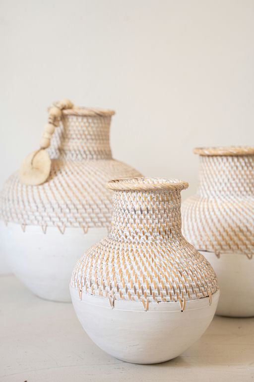 Handmade woven ceramic vase placed on a shelf in a Scandinavian-style interior