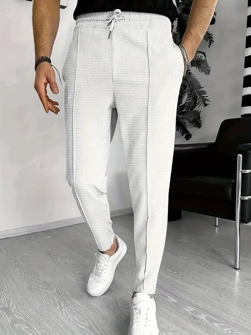 Men's drawstring trousers with structured woven texture and tapered leg