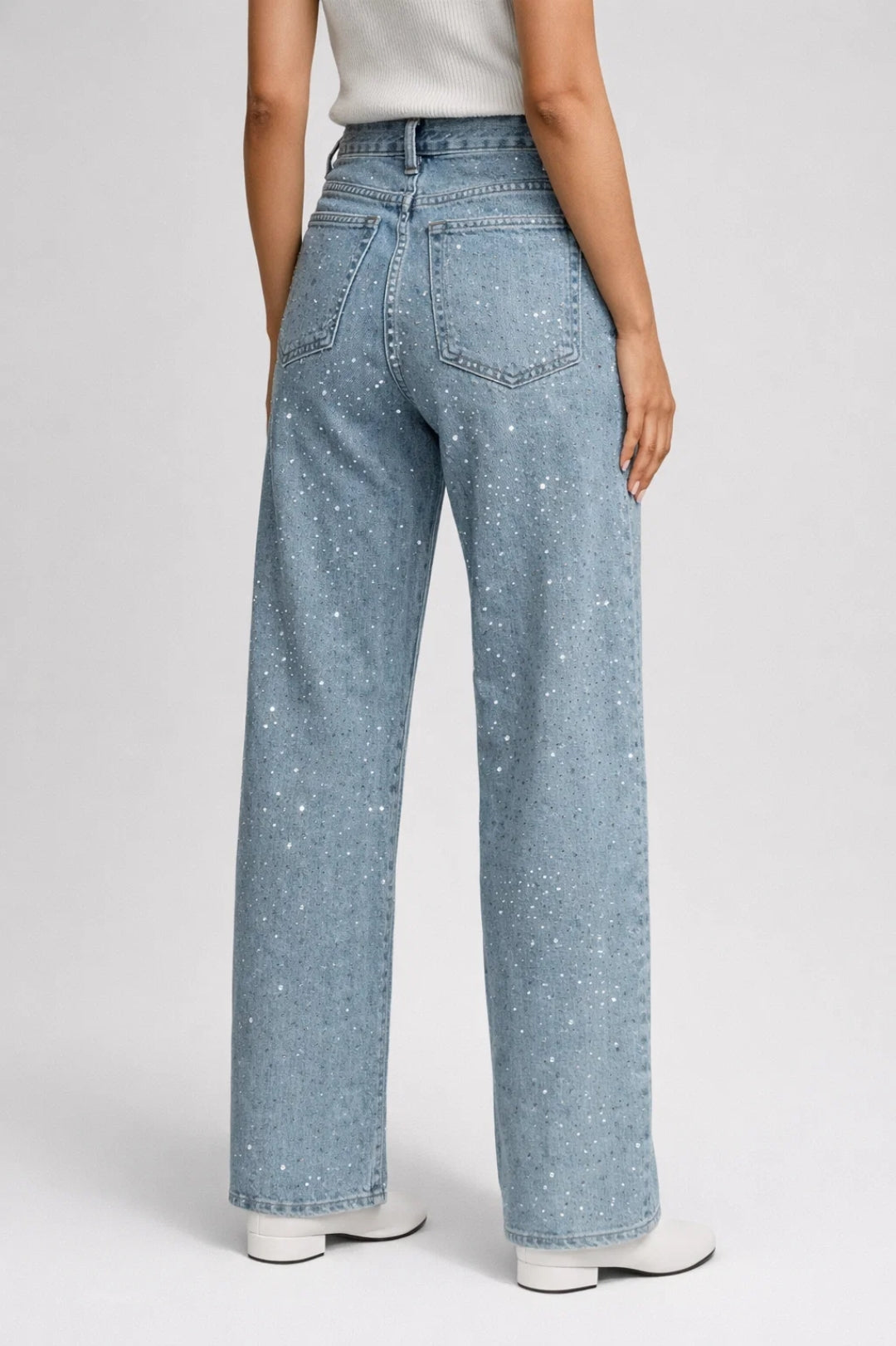 High-waisted women's denim jeans with allover rhinestone embellishments and belt loops