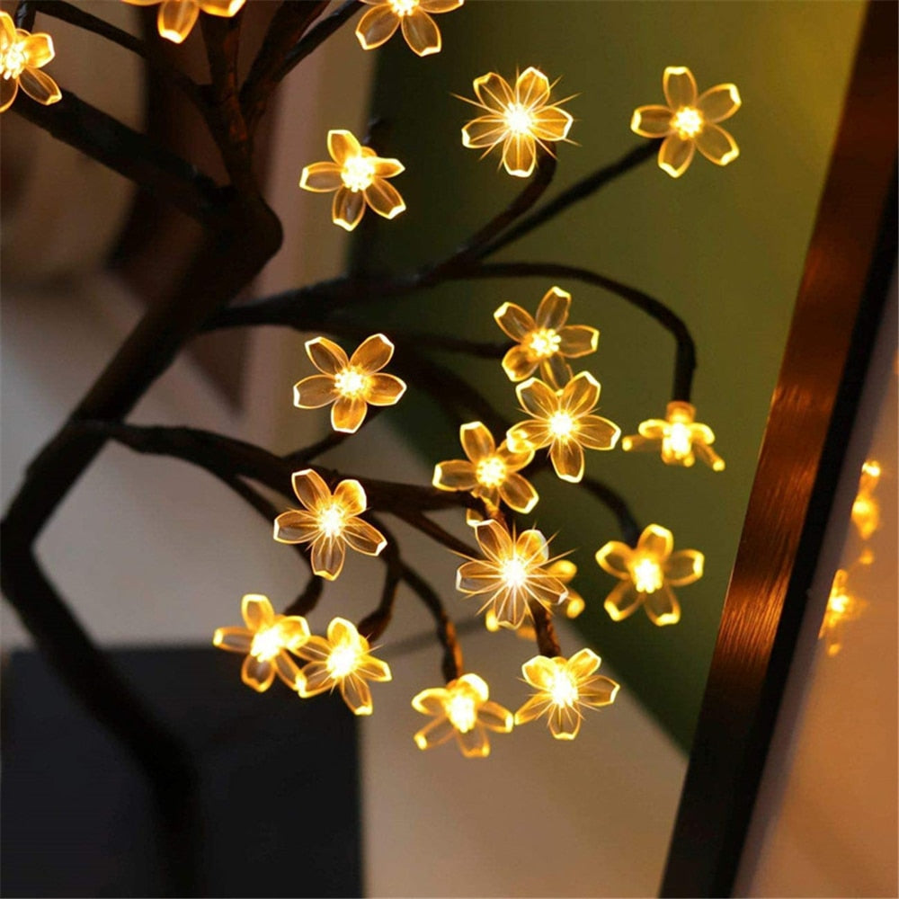 Decorative LED Cherry Blossom tree lamp creating a warm ambient glow in a room setting