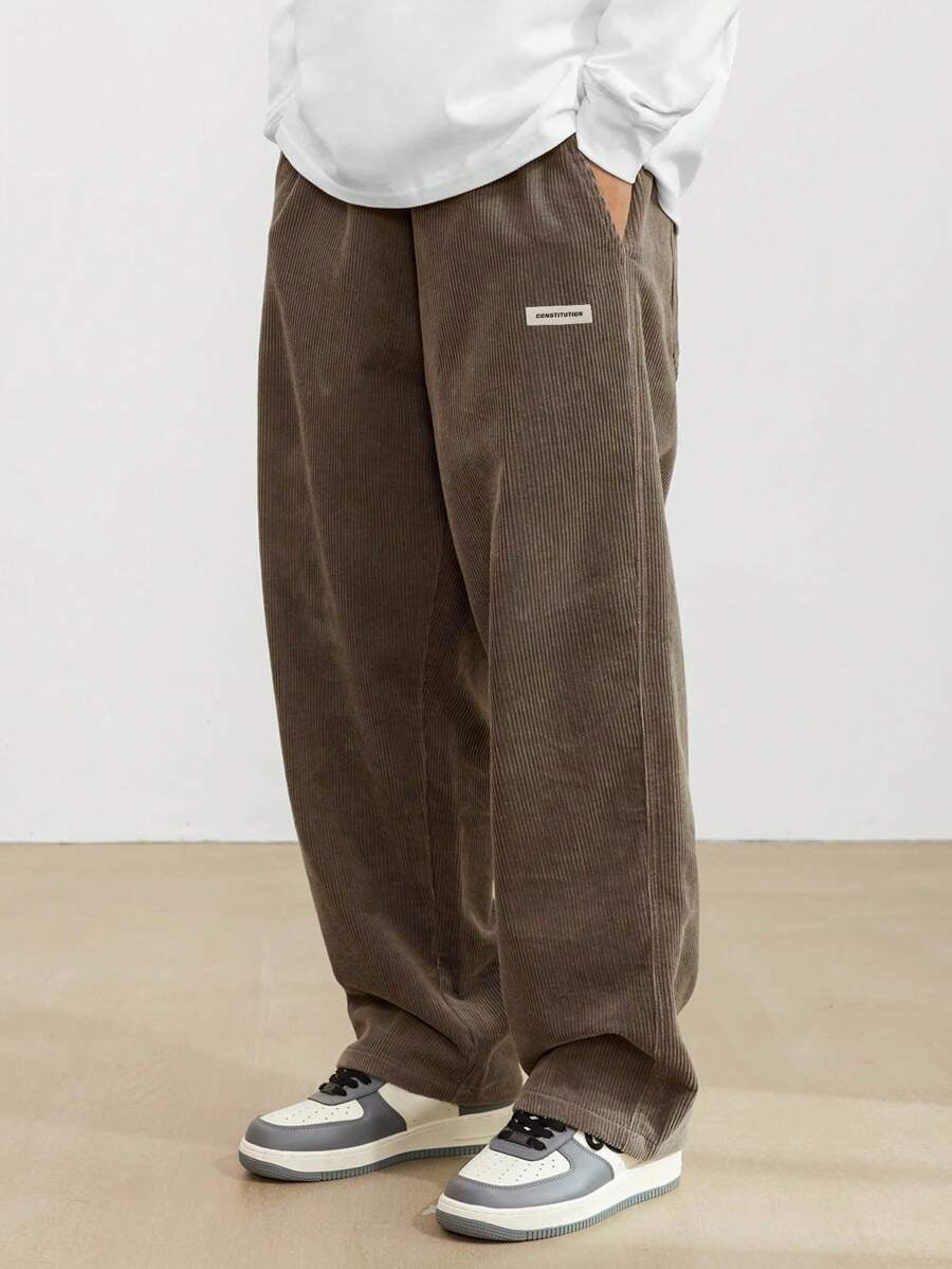 Men's wide leg corduroy trousers, three-quarter angle showing drape and fit