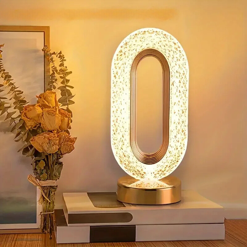 Acrylic LED table lamp with oval sculptural frame on a stable metal base