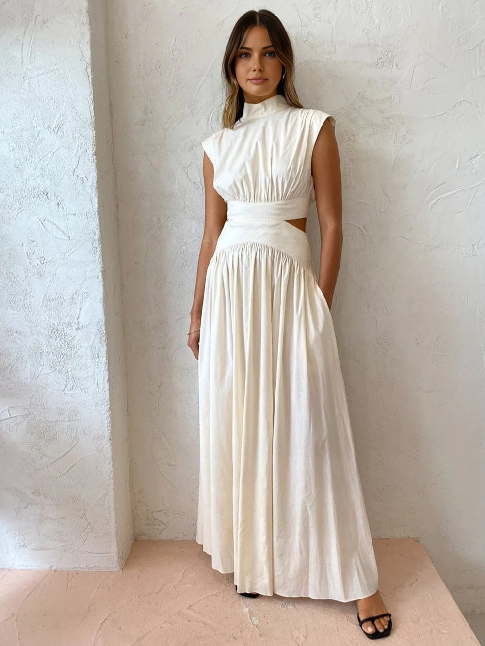 Women's long sleeveless dress with high neckline, defined waist, and side cut-out detail