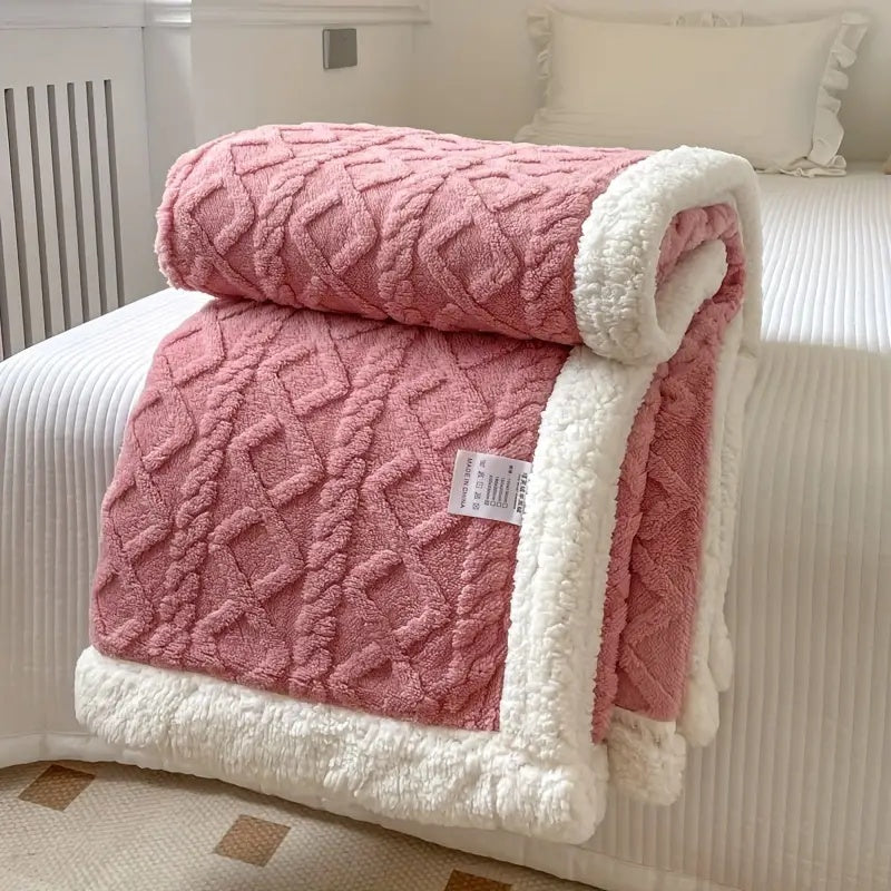 Plush sherpa blanket arranged on a bed, showcasing its size and warm textured design