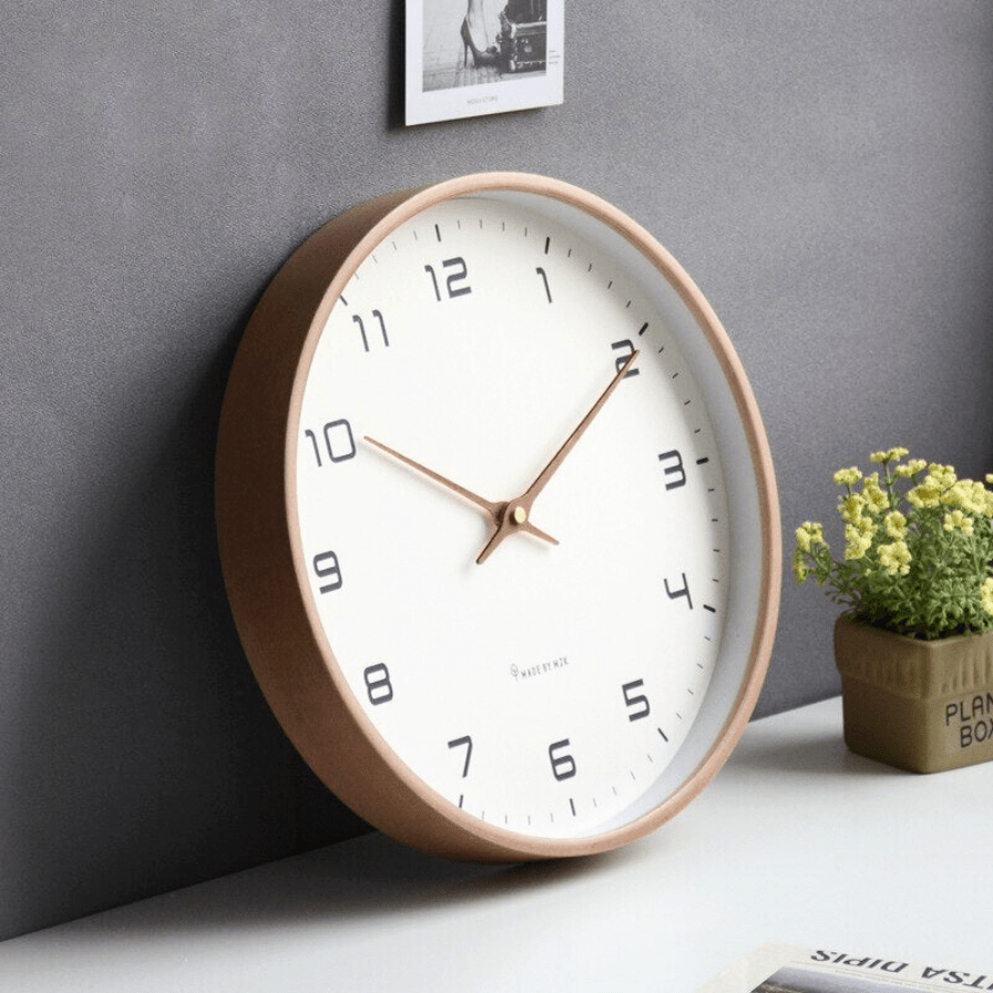Wooden wall clock with glass front shown against a neutral home decor backdrop