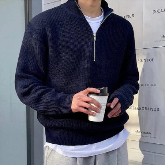 Navy blue men's half-zip knit sweater showing ribbed surface and zip detail, side angle