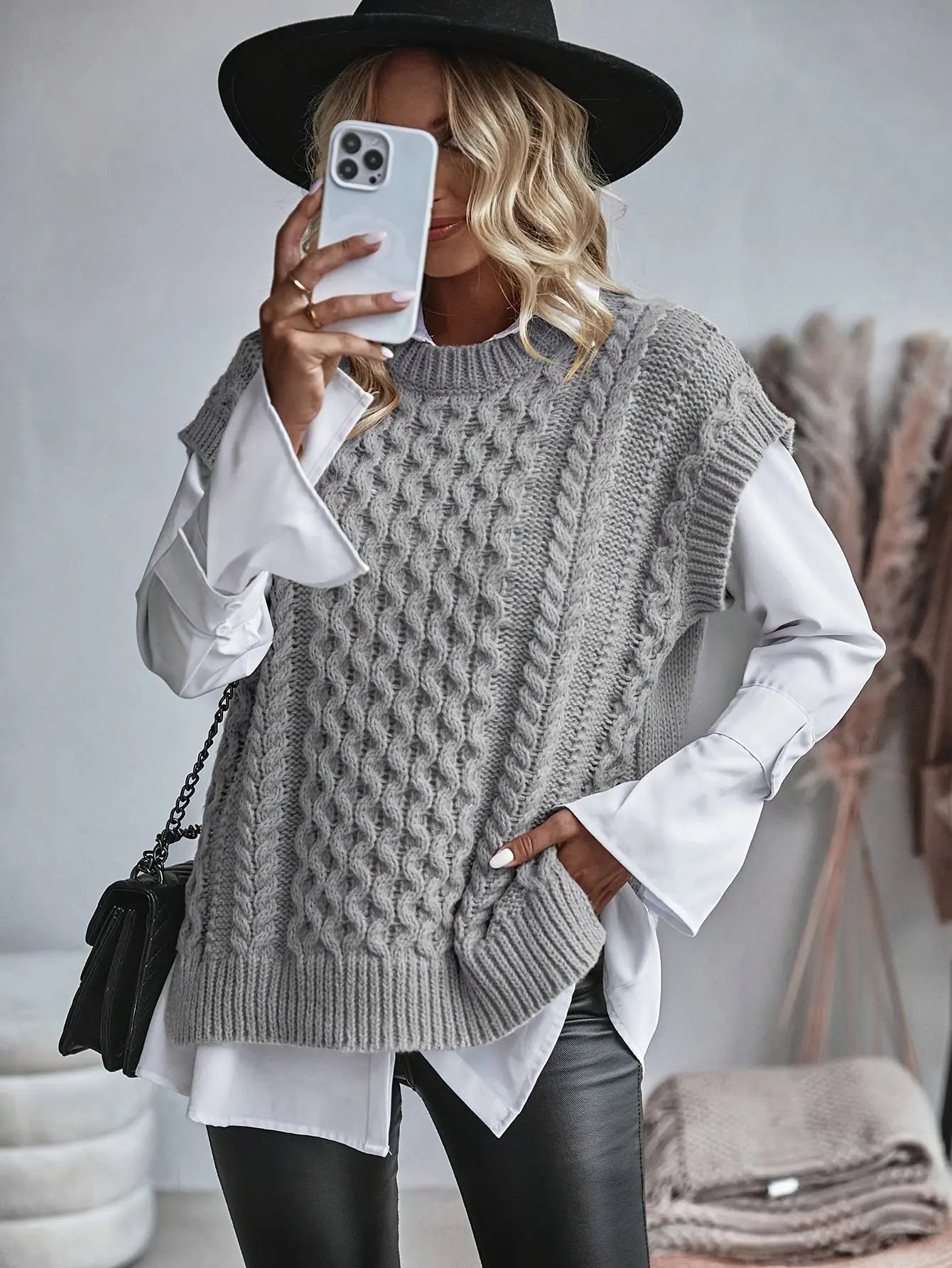 Close-up of cable knit pattern and ribbed hem detail on women's sleeveless sweater