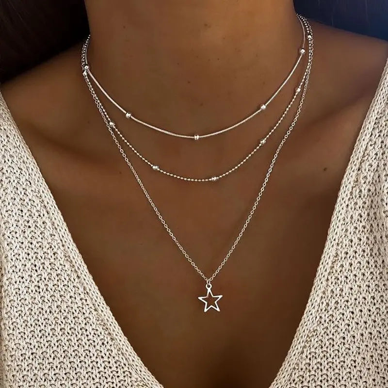 Close-up of star-shaped pendant on a layered multi-chain necklace with lobster clasp