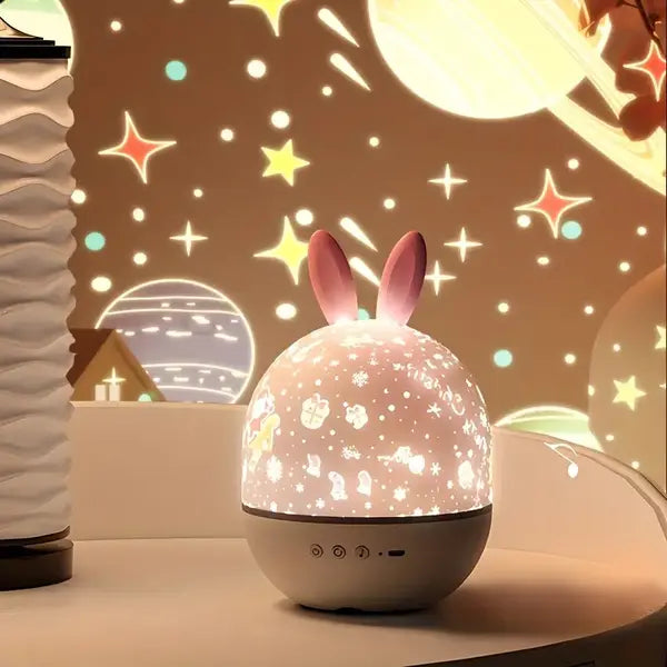 Kids' rechargeable starry sky projector with bunny ear dome glowing on a bedside surface