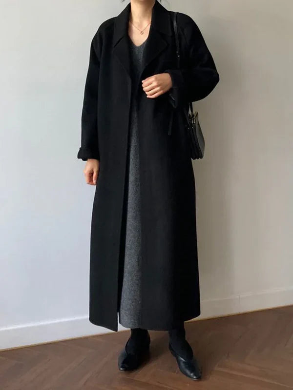 Long polyester women's coat with waist belt and classic lapel collar, styled view
