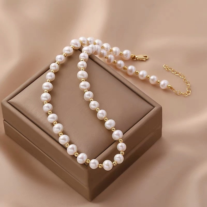 Pearl necklace for women with round synthetic pearls and metallic accents on an adjustable extension chain