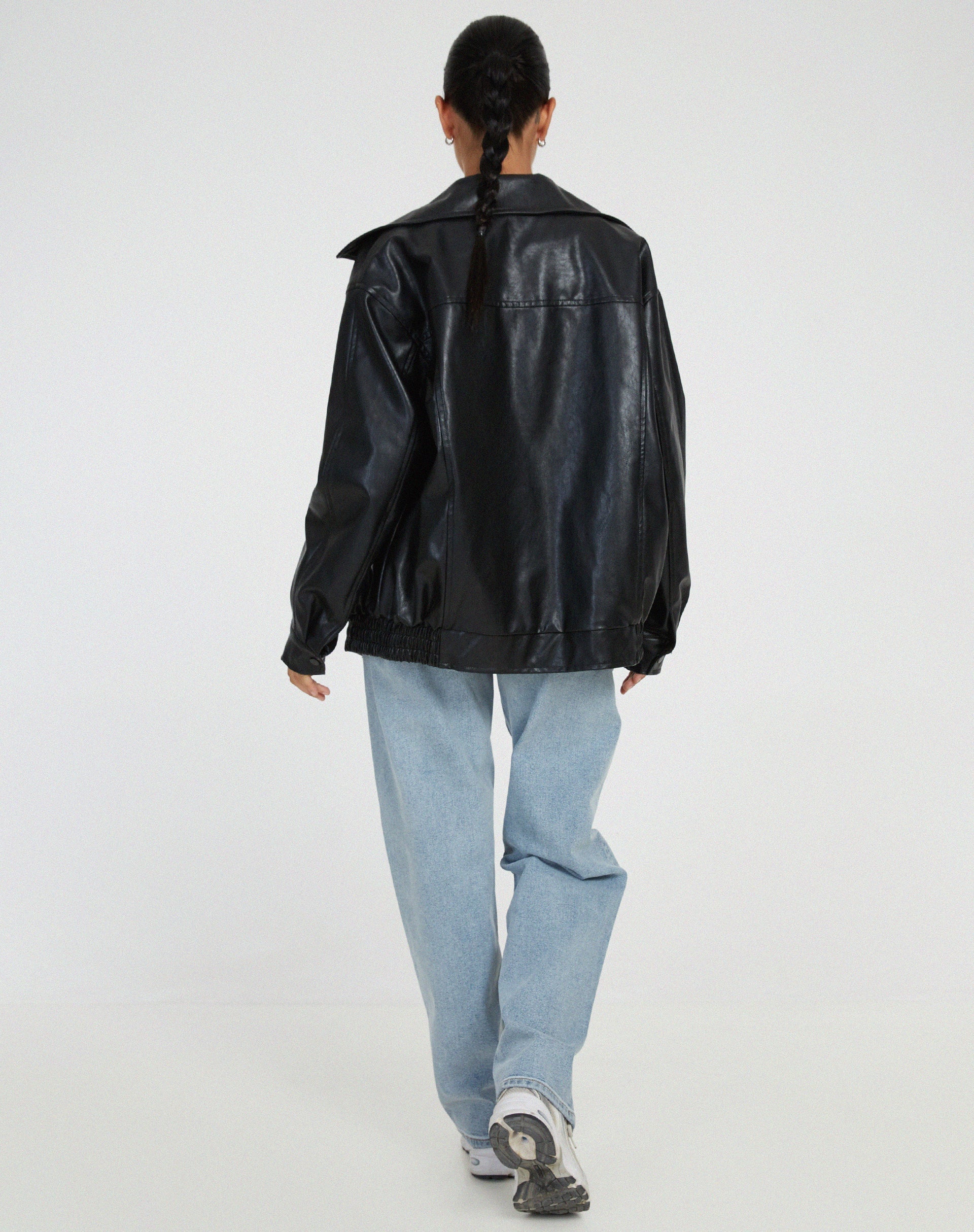 Close-up detail of women's vegan leather jacket showing wide turn-down collar and front zipper