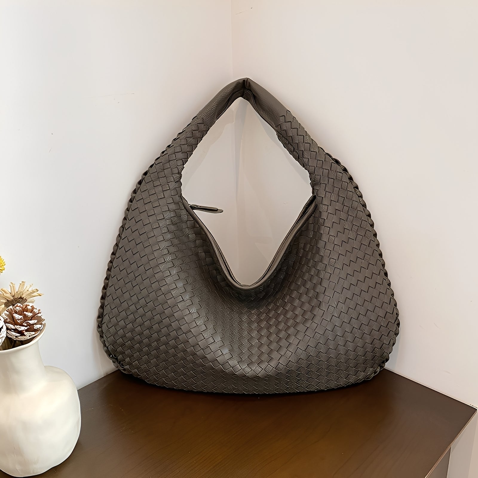 Women's woven faux leather shoulder bag laid flat, showing full silhouette and zipper